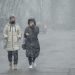 epa09812797 Two young women walk on the street during heavy snowfall in downtown Chisinau, Moldova, 09 March 2022.  EPA/DUMITRU DORU