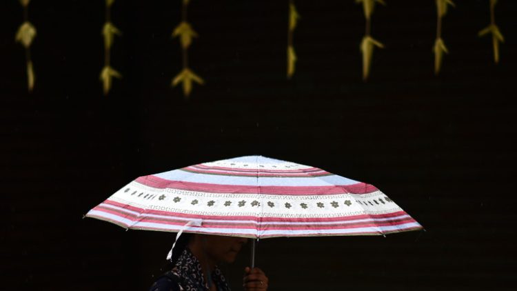 epa10224419 A woman walks with an umbrella during the rain, in Chennai, India, 05 October 2022. The Indian Meteorological Department (IMD) has predicted light to moderate rainfall and isolated heavy rainfall with thunderstorms over the next few days at isolated places in the state of Tamil Nadu.  EPA/IDREES MOHAMMED